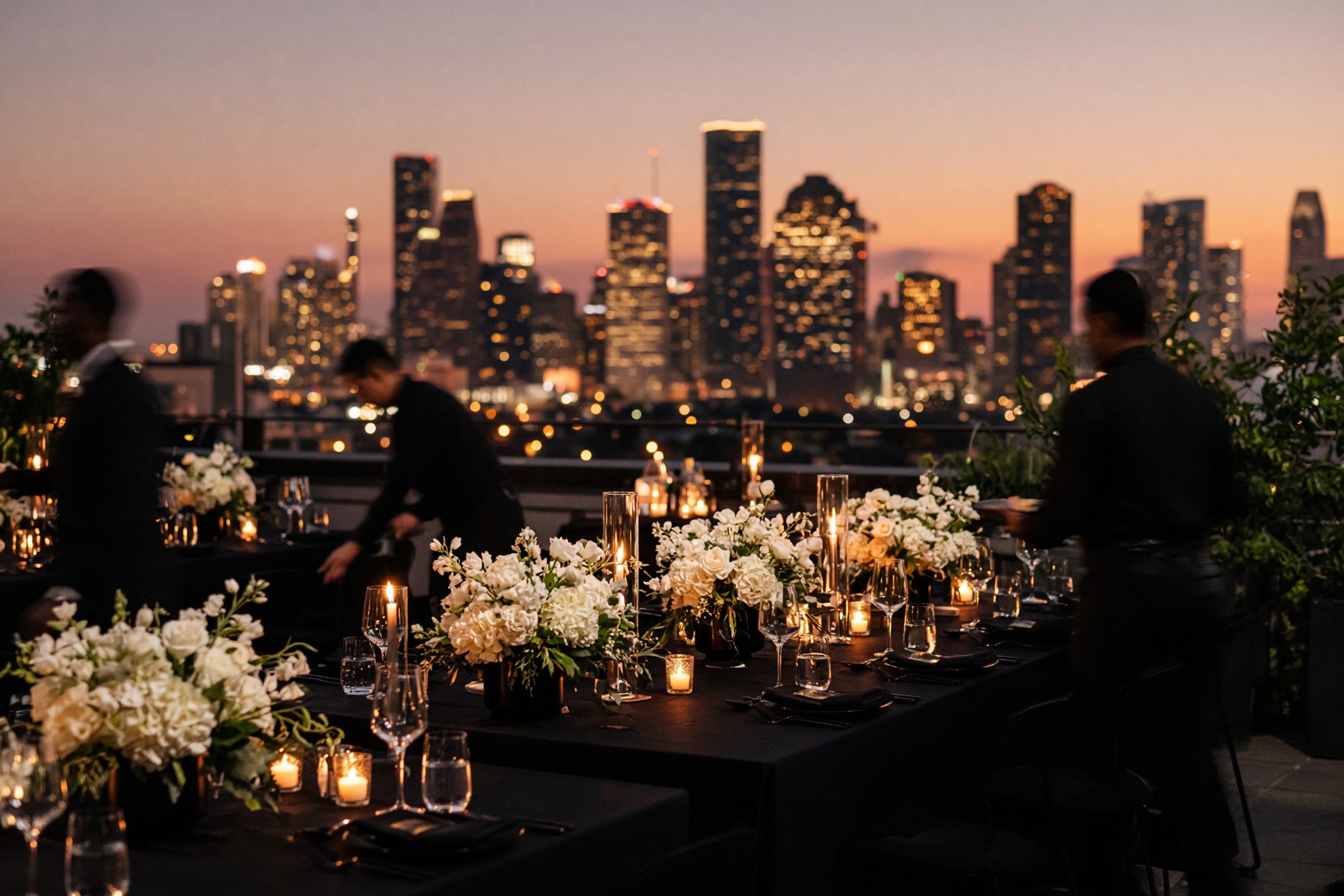 A Houston reception set at dusk with candlelit tables and the skyline